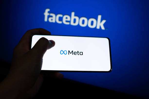 Meta logo is shown on a device screen. Meta is the new corporate name of Facebook. Social media platform will change to Meta to emphasize its metaverse vision.