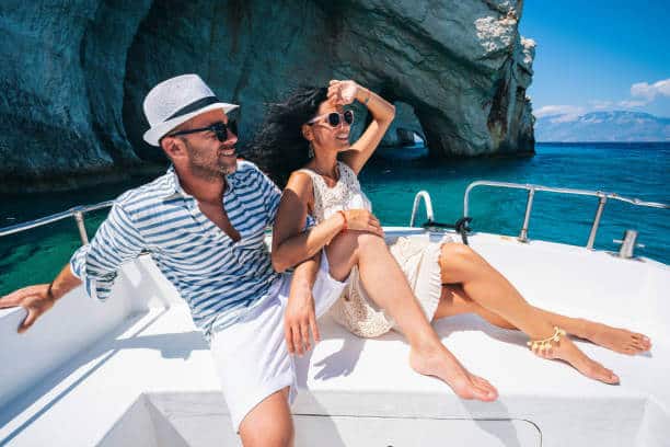 Couple in love enjoying summer vacations on a yacht in Zakynthos Greece - Navagio beach and having fun traveling