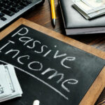 How to generate Passive income inscription on the board and a bundle of bills.