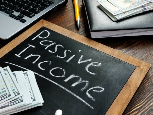 How to generate Passive income online inscription on the board and a bundle of bills.