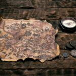 Old map and compass on a adventurer table background. Treasure hunt concept.