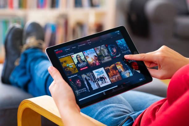 stanbul, Turkey - July 1 2018: Woman using tablet computer and looking an online streaming platform. The tablet pc is an iPad Air 2, developed by Apple Inc.