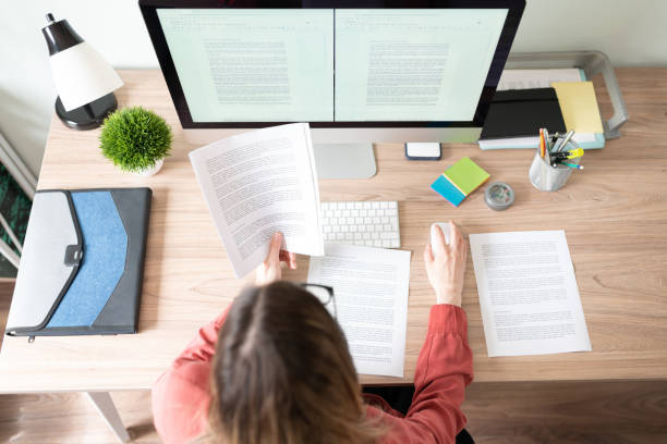 Top view of the workspace and office of a female translator working on a document and checking some references